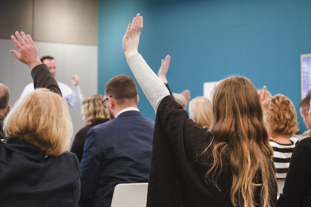 People-with-hands-up-at-seminar