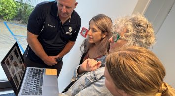 Man And Three Women Looking At Laptop Having Discussion