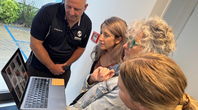 Man And Three Women Looking At Laptop Having Discussion