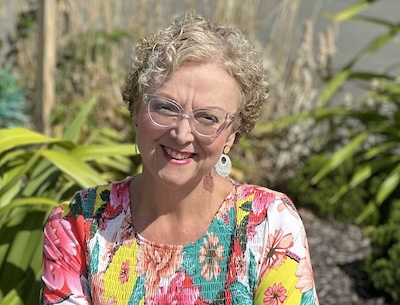 Lady Smiling In Front Of Garden