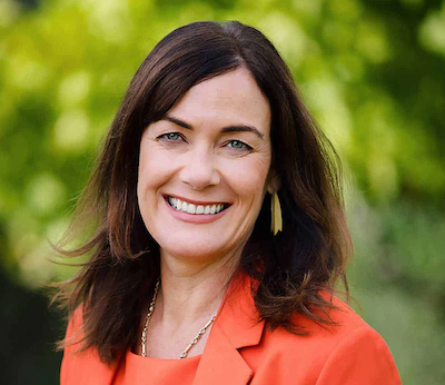 Lady Smiling In Front Of Garden